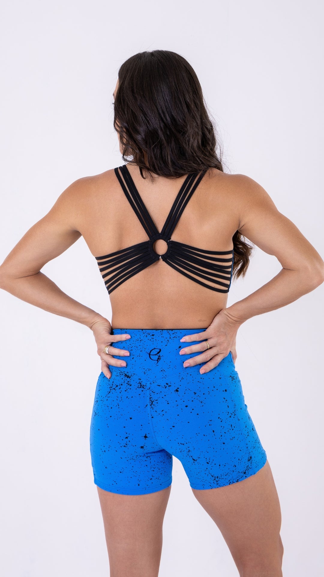 Blue-black speckled sports bra with thin strappy back and silver buckle; medium support.